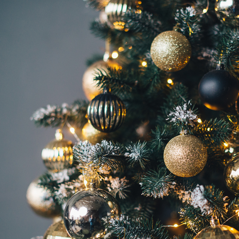 Christmas tree decorated with garlands and golden balls on a dark background